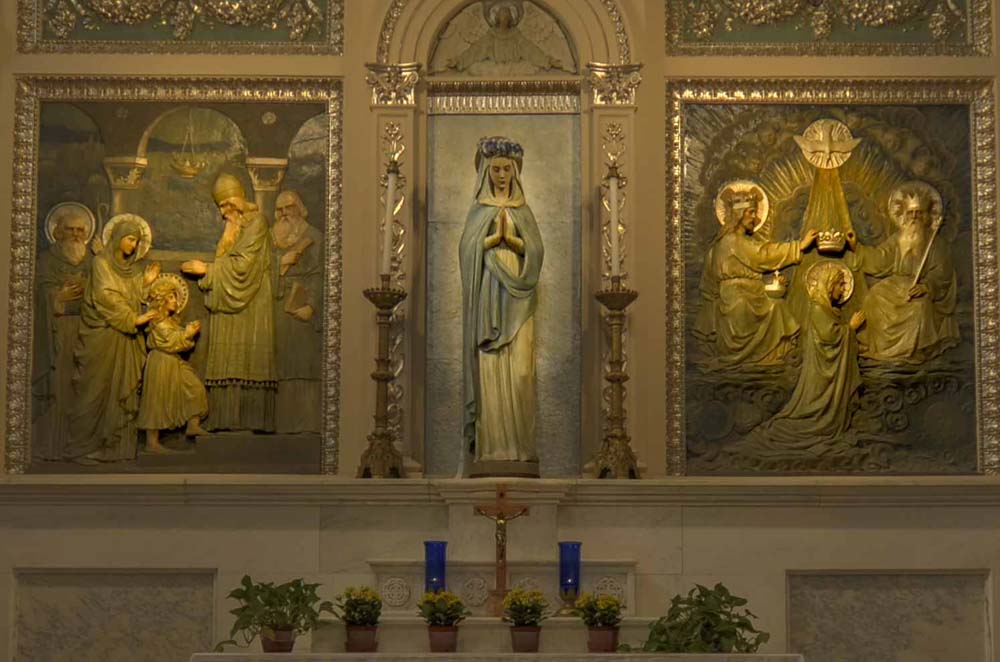 Close up of statue and panels above Virgin Mary altar