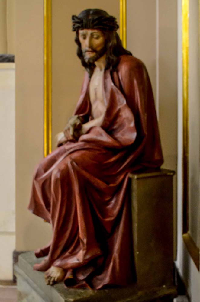 Statue of tormented Jesus, set at top of stairs on right side of rise