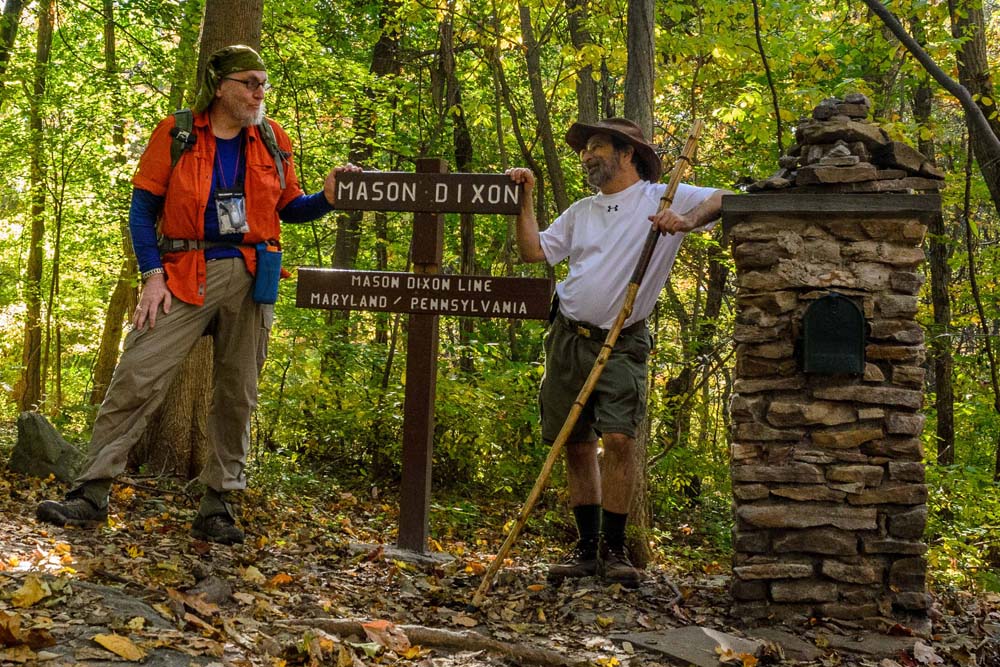 Howard and myself standing by sign indicating location of where the Mason Dixon Line crosses the Appalachian Trail.  There is also a stone marker with mailbox with registration book for hikers to make entries