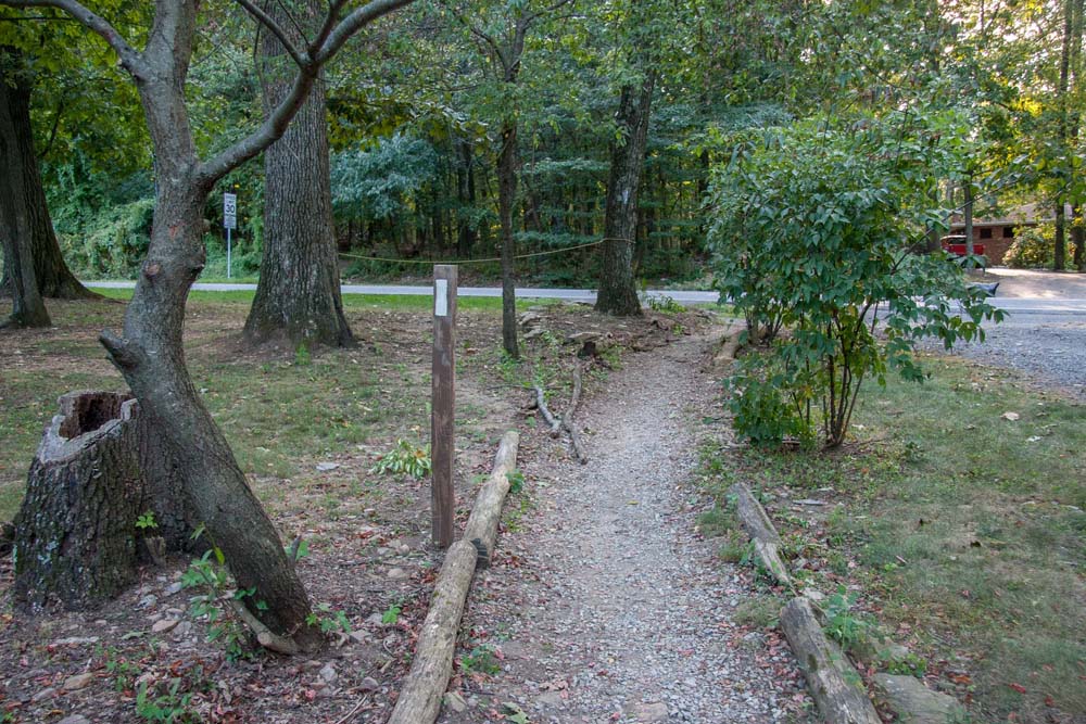 Trail passes between two private properties, and a rope prevents hikers from cutting across corner of a property.  The trail leads to Boonsboro Mountain Road visible nearby.
