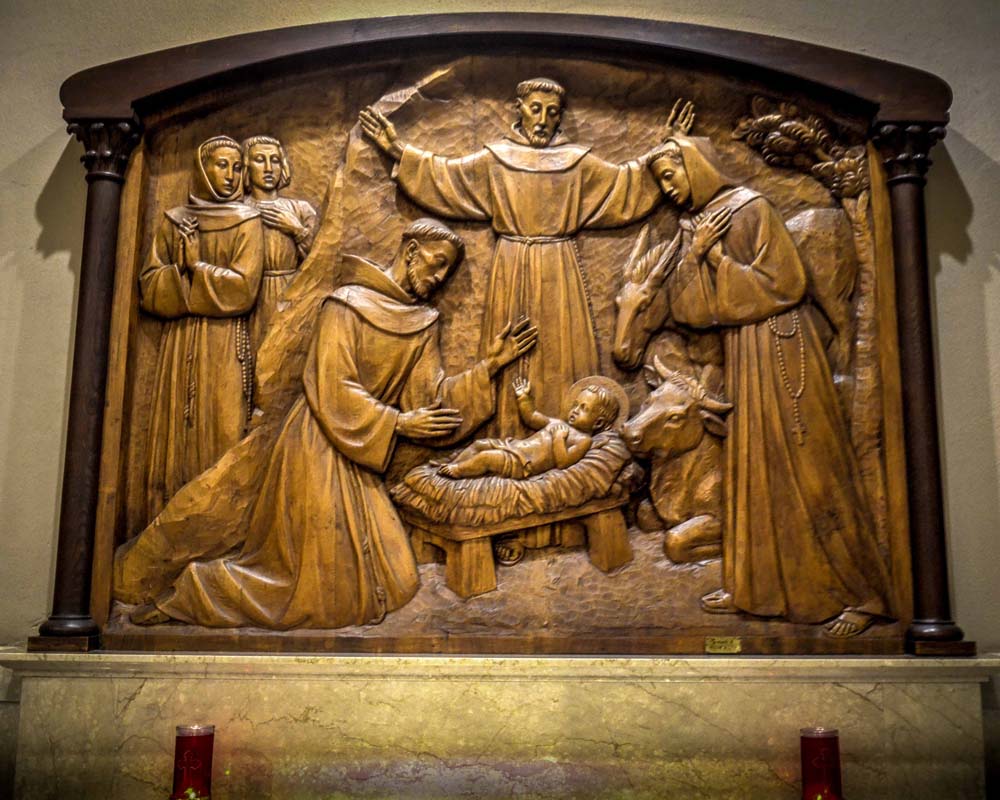 Saint Francis Chapel, wooden relief of Saint Francis overseeing baby Jesus and Holy Family