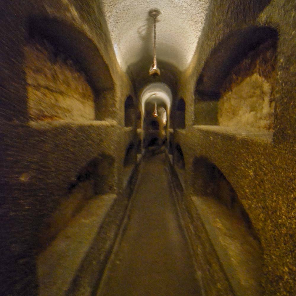 View of catacomb hallway, with niches in the walls on either side for burial of Roman Christians